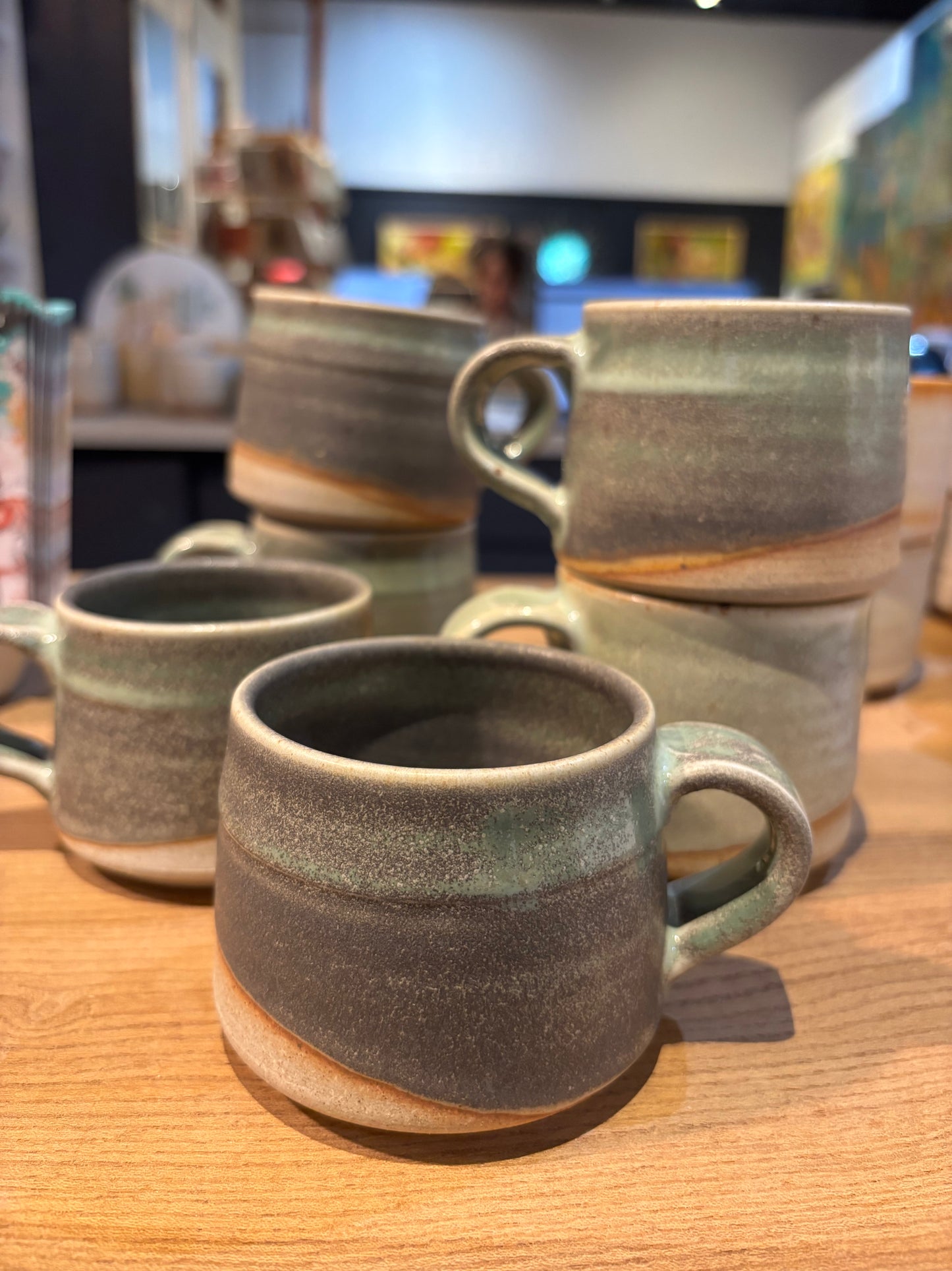 Set of ceramic mugs on a wooden surface green grey natural 
