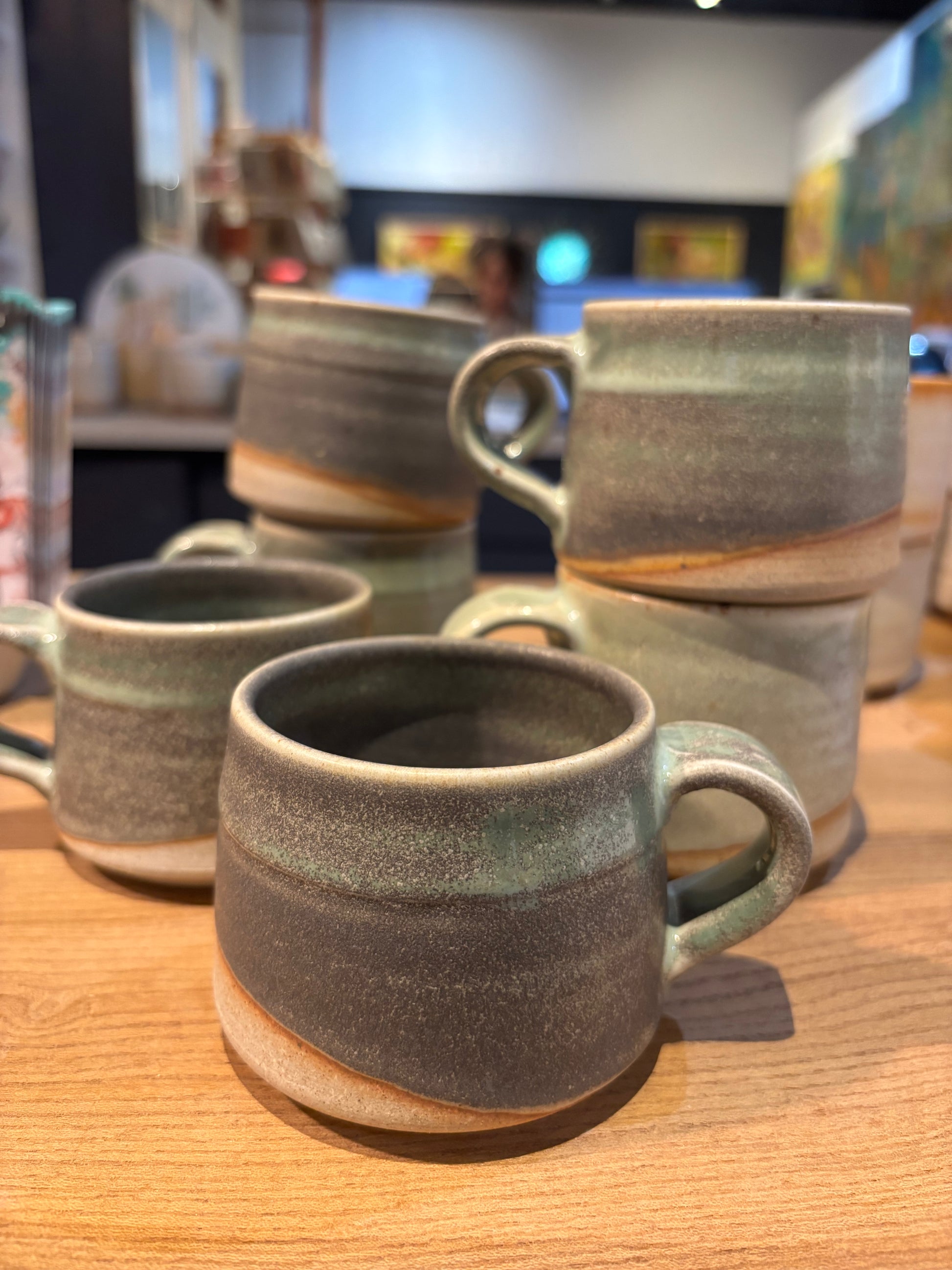 Set of ceramic mugs on a wooden surface green grey natural 