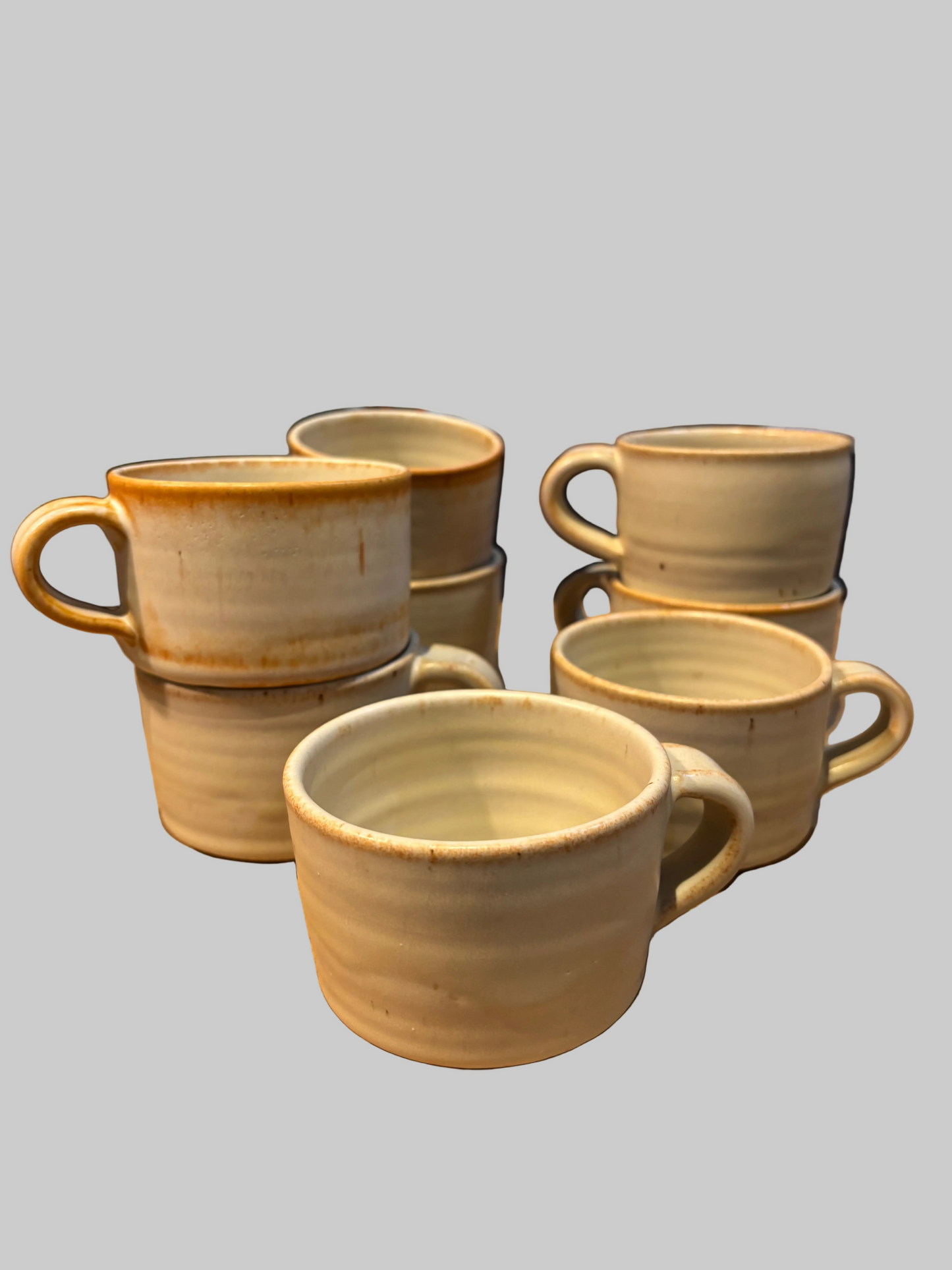 Set of ceramic mugs on a wooden table with a blurred background