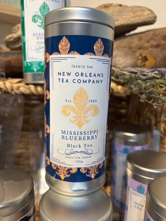 New Orleans Tea Company Mississippi Blueberry black tea canister on a wooden surface with other tea cans.