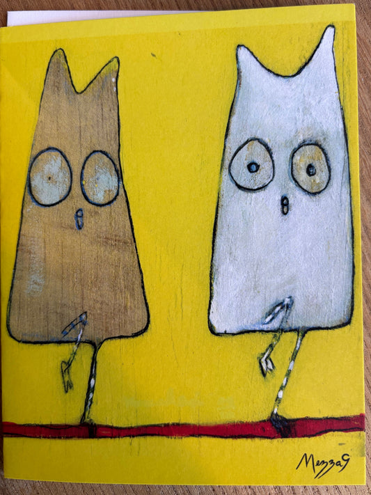 Greeting card front featuring a whimsical illustration of two cartoon owls on a bright yellow background, placed on a wooden surface. The left owl is brown with a surprised face, and the right owl is white with a neutral expression. 4 owls on the card in total. Art by Mezza9


