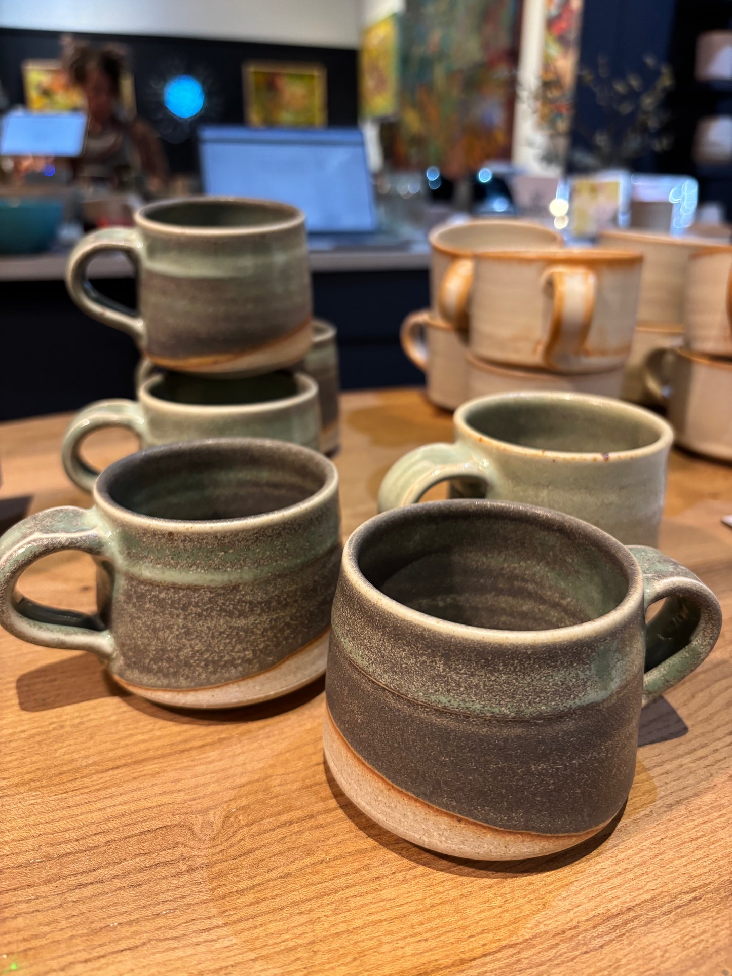 Collection of ceramic mugs on a wooden surface with a blurred indoor background