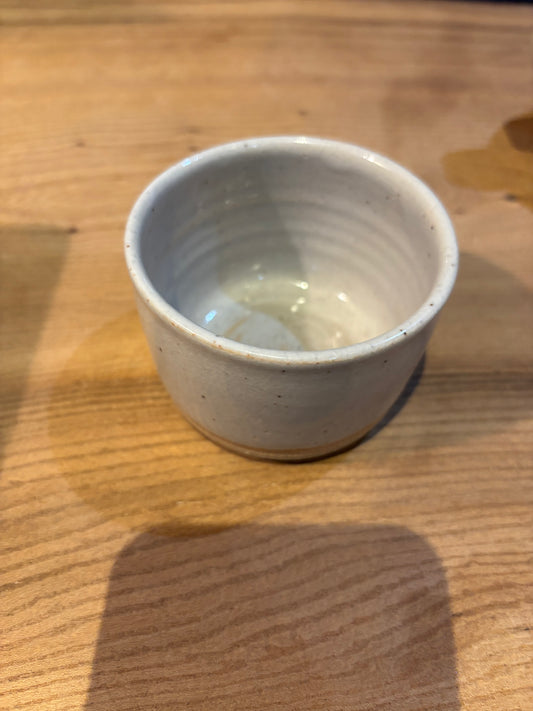 Small ceramic espresso cup on a wooden surface
